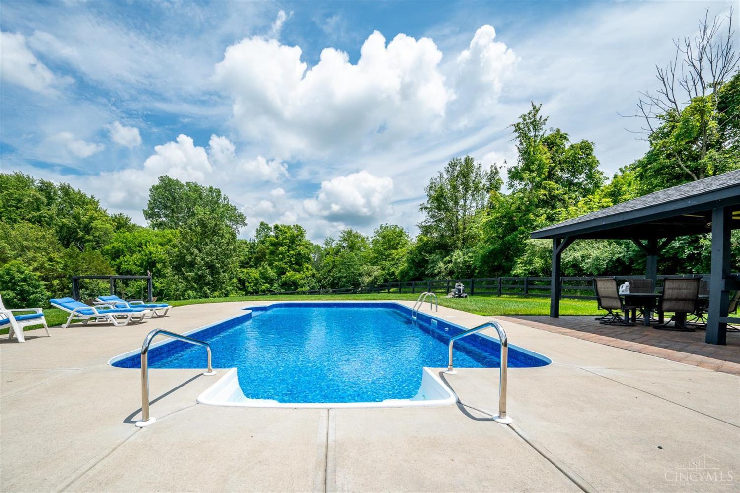 Blue swimming pool and dark timber pavilion at 744 Cedar Ridge Drive, Turtle Creek Township.