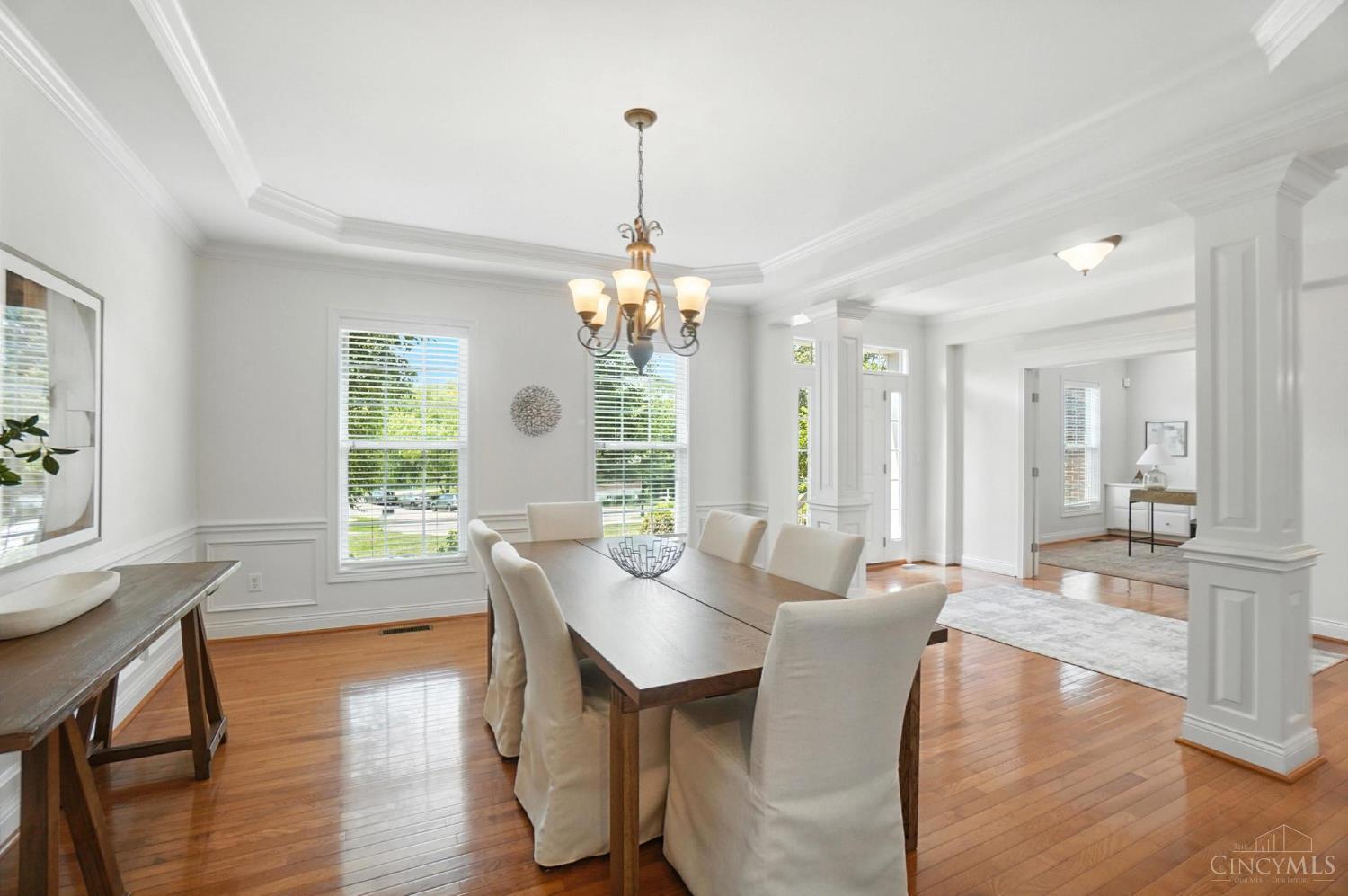 Light-filled dining room with white columns and cream chairs at 124 Isabella Court, Loveland.