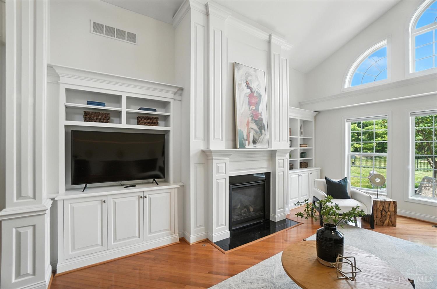 White paneled fireplace wall and tall arched windows at 124 Isabella Court, Loveland.