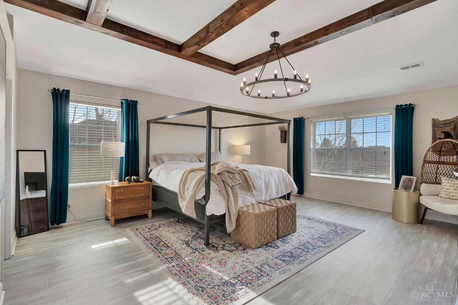 Airy primary bedroom with timber ceiling beams at 4853 Whispering Creek Court.